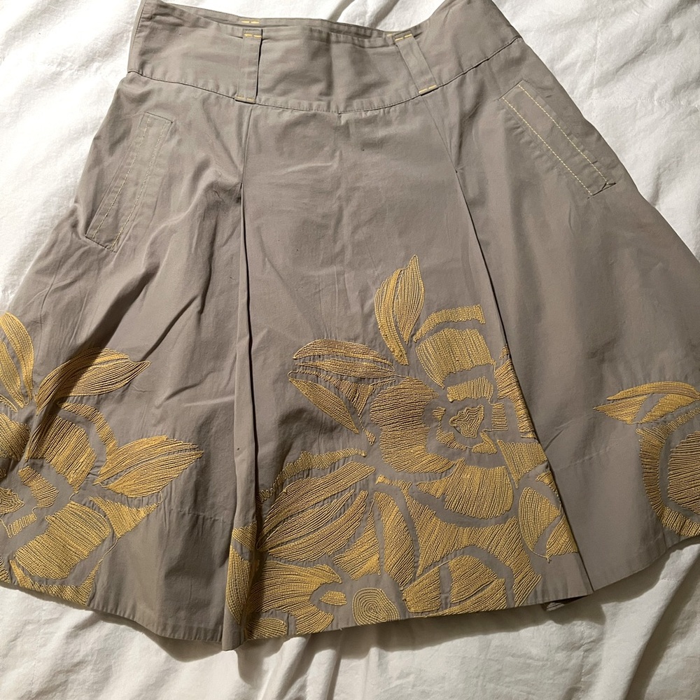 Tan midi skirt with yellow embroidery flowers.